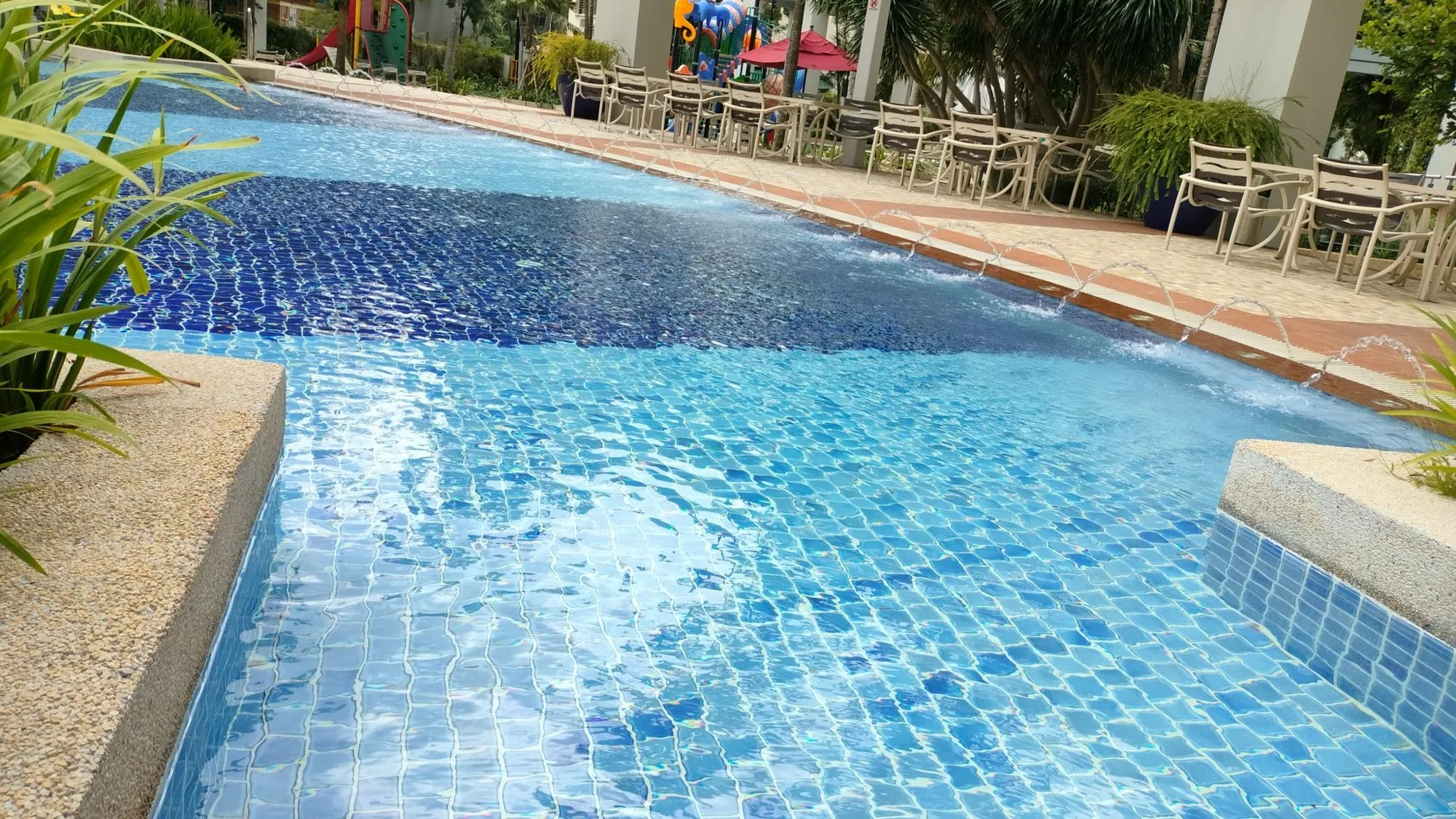 Piscina con mosaico azul y agua cristalina